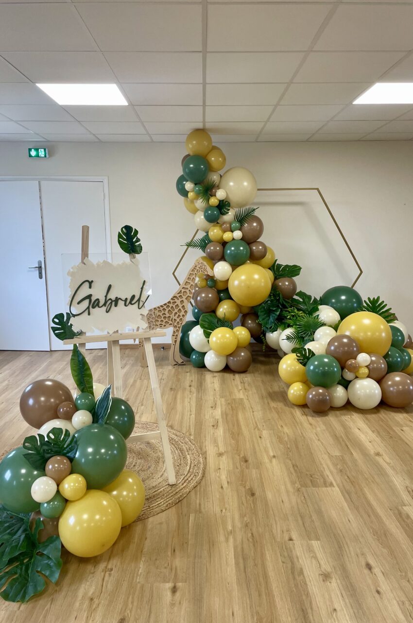 Décoration pour un anniversaire au thème jungle avec une cascade de ballons et son panneau de Bienvenue personnalisé, réalisé par une décoratrice du 95